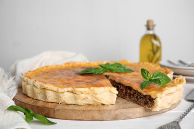 Photo of Delicious pie with minced meat on white wooden table