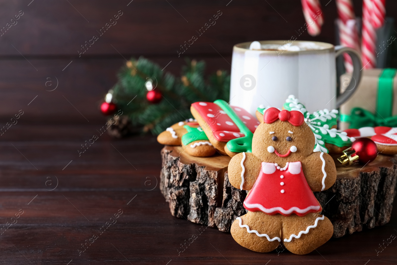 Photo of Decorated Christmas cookies and cup of delicious drink on wooden table. Space for text