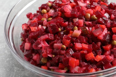 Photo of Bowl of delicious fresh vinaigrette salad on table, closeup