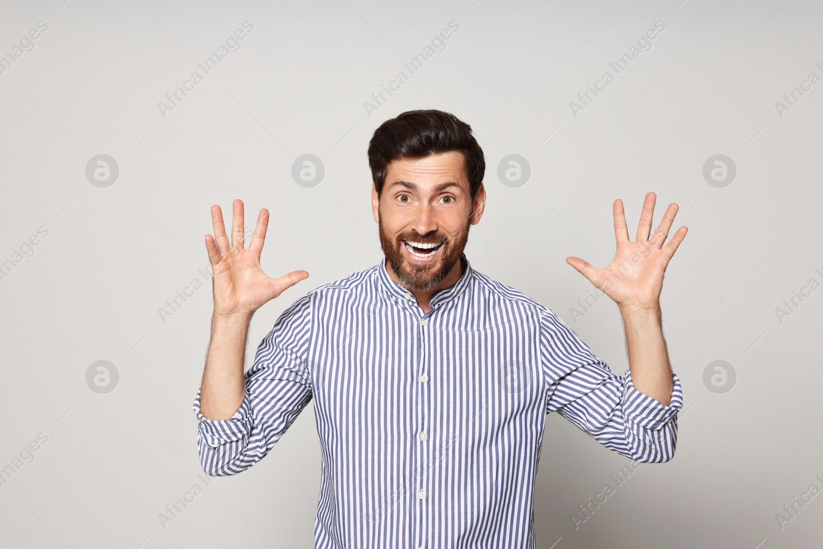 Photo of Portrait of emotional bearded man on grey background