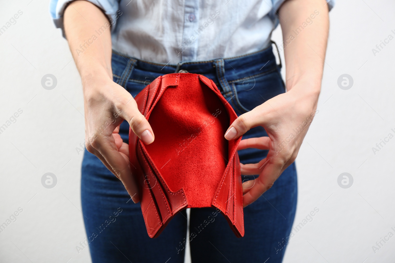 Woman showing empty wallet on light background, closeup Photo of Woman showing empty wallet on light background, closeup