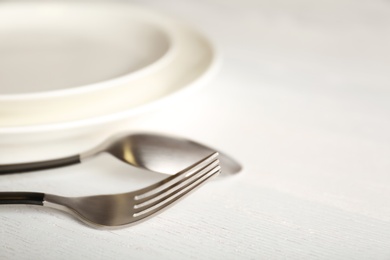 Photo of Empty dishware and cutlery on wooden background, close up view. Table setting