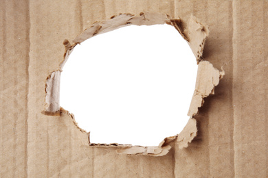 Hole in brown cardboard on white background