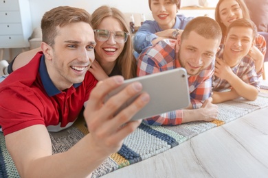 Happy friends taking selfie indoors