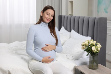 Beautiful pregnant woman with long hair in bedroom