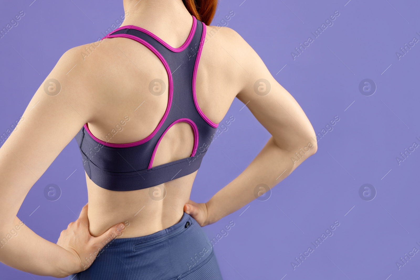 Photo of Woman wearing sportswear on violet background, back view. Space for text