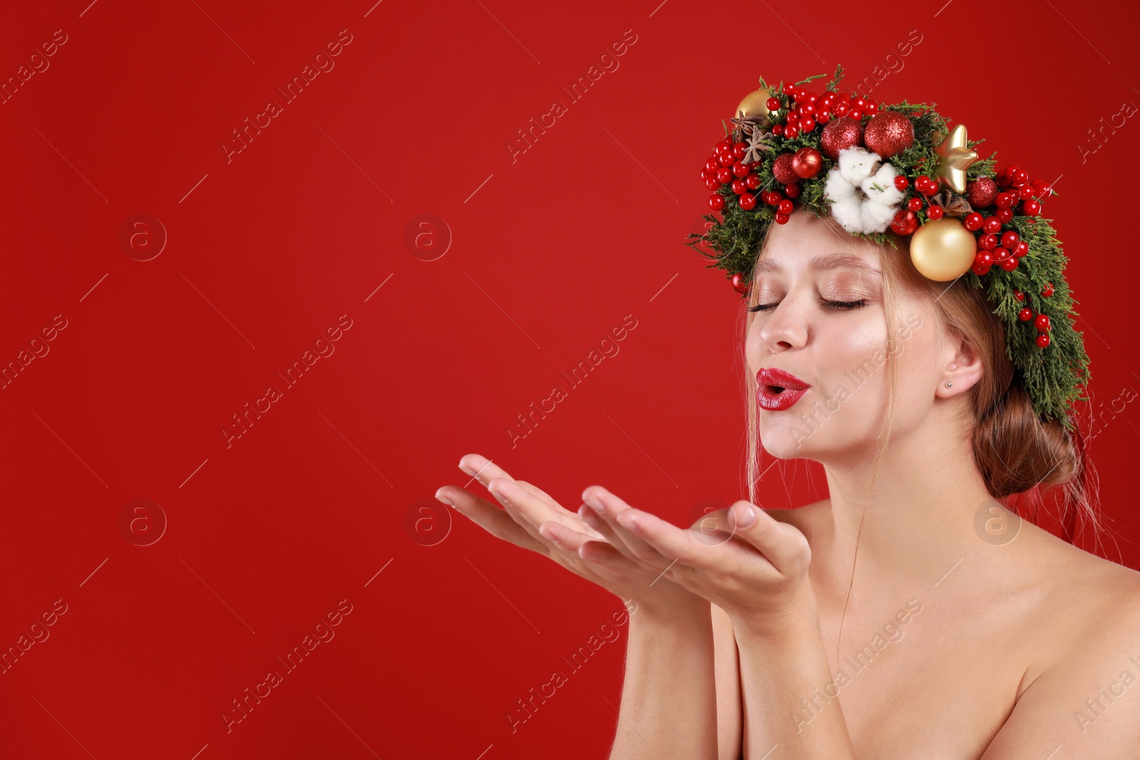 Photo of Beautiful young woman wearing Christmas wreath on red background. Space for text