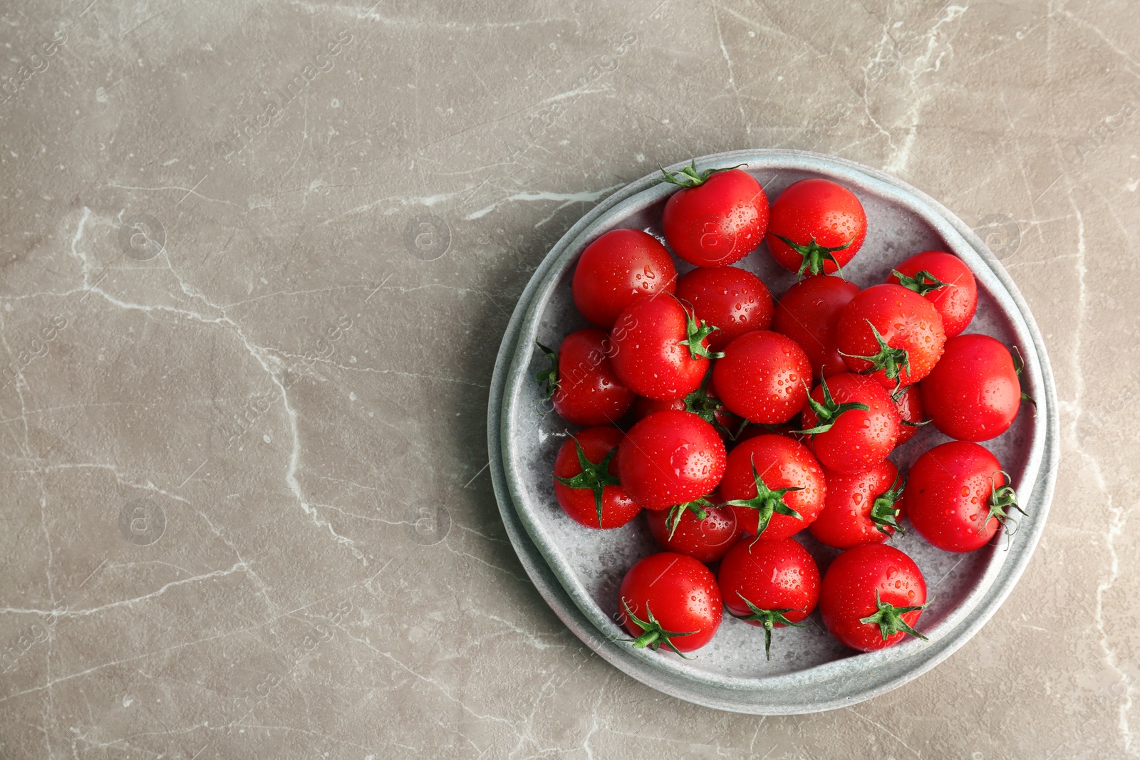 Photo of Plates with fresh ripe tomatoes on grey background, top view