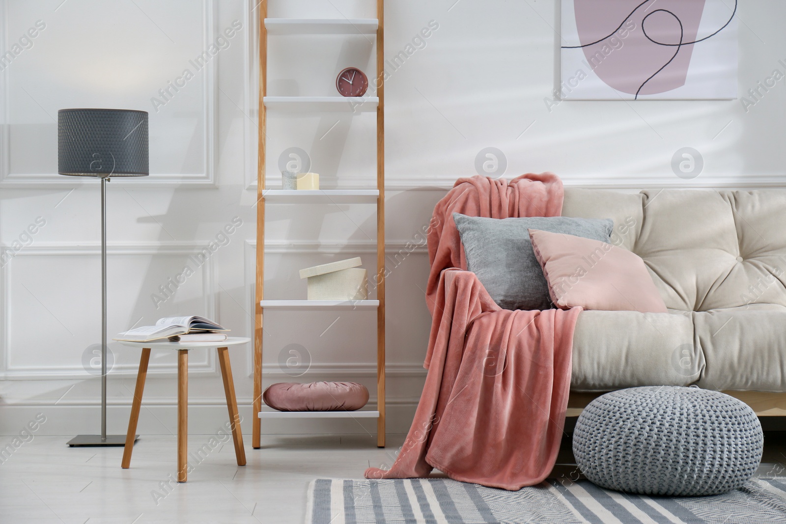 Photo of Modern living room interior with comfortable sofa and pink blanket