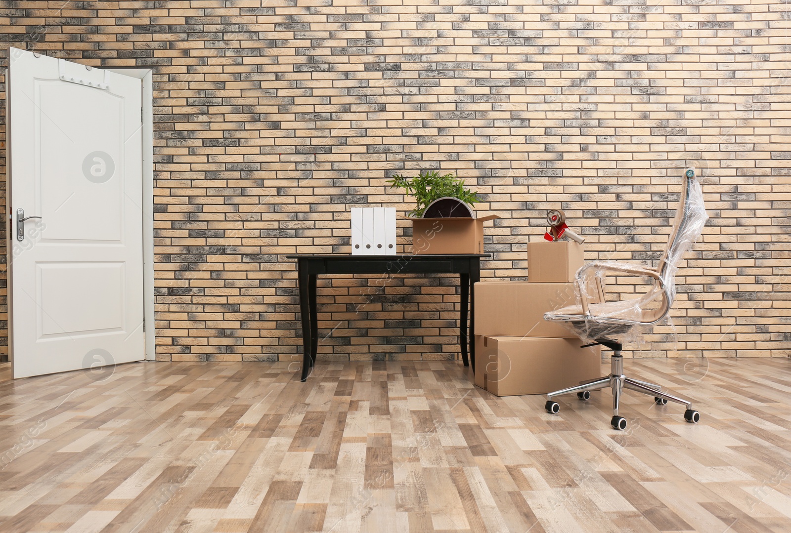 Photo of Furniture and moving boxes in empty office