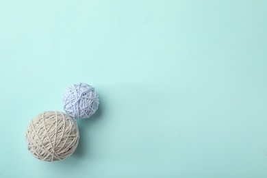 Soft colorful woolen yarns on light blue background, flat lay. Space for text