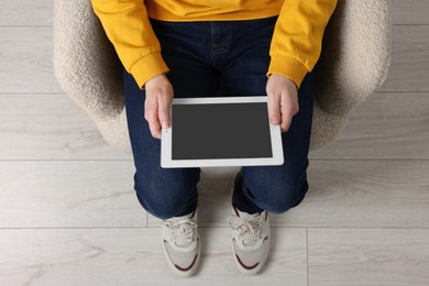 Photo of Man working with tablet in armchair, top view