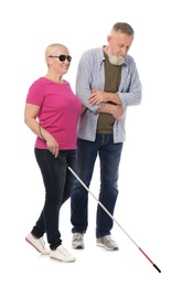 Photo of Mature man helping blind person with long cane on white background