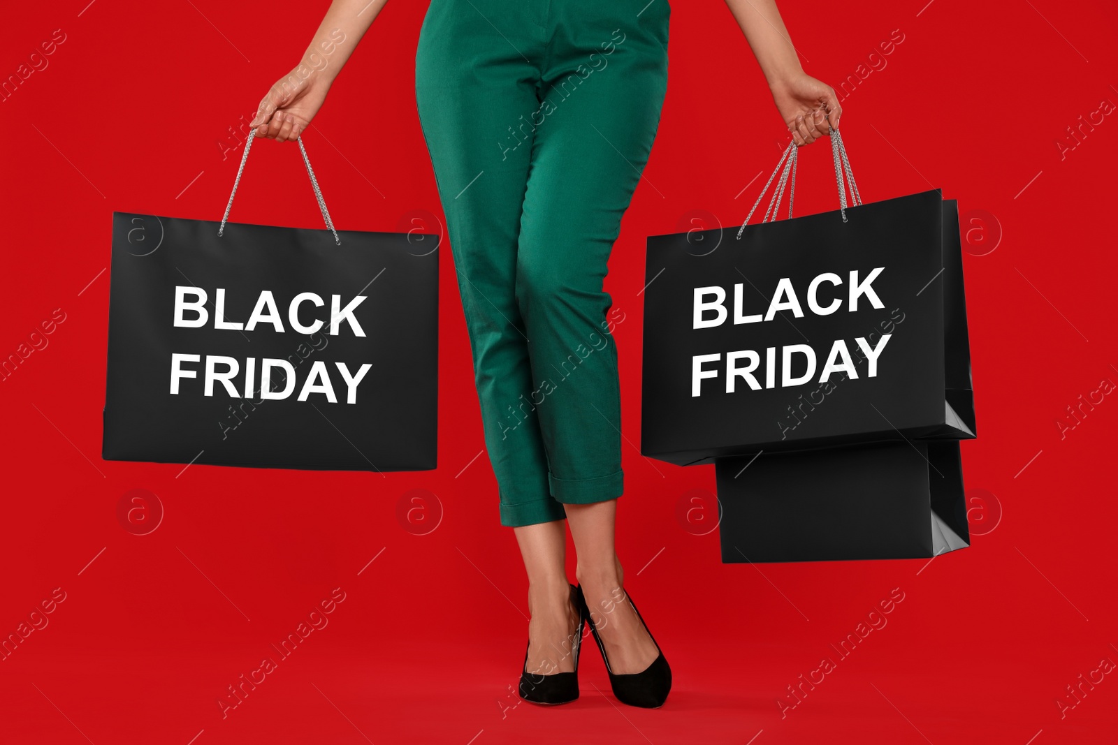 Photo of Woman with shopping bags on red background, closeup. Black Friday