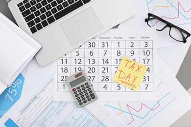 Photo of Flat lay composition with calendar, calculator and glasses on table. Tax day