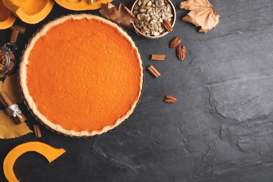 Photo of Flat lay composition with delicious homemade pumpkin pie on black table. Space for text