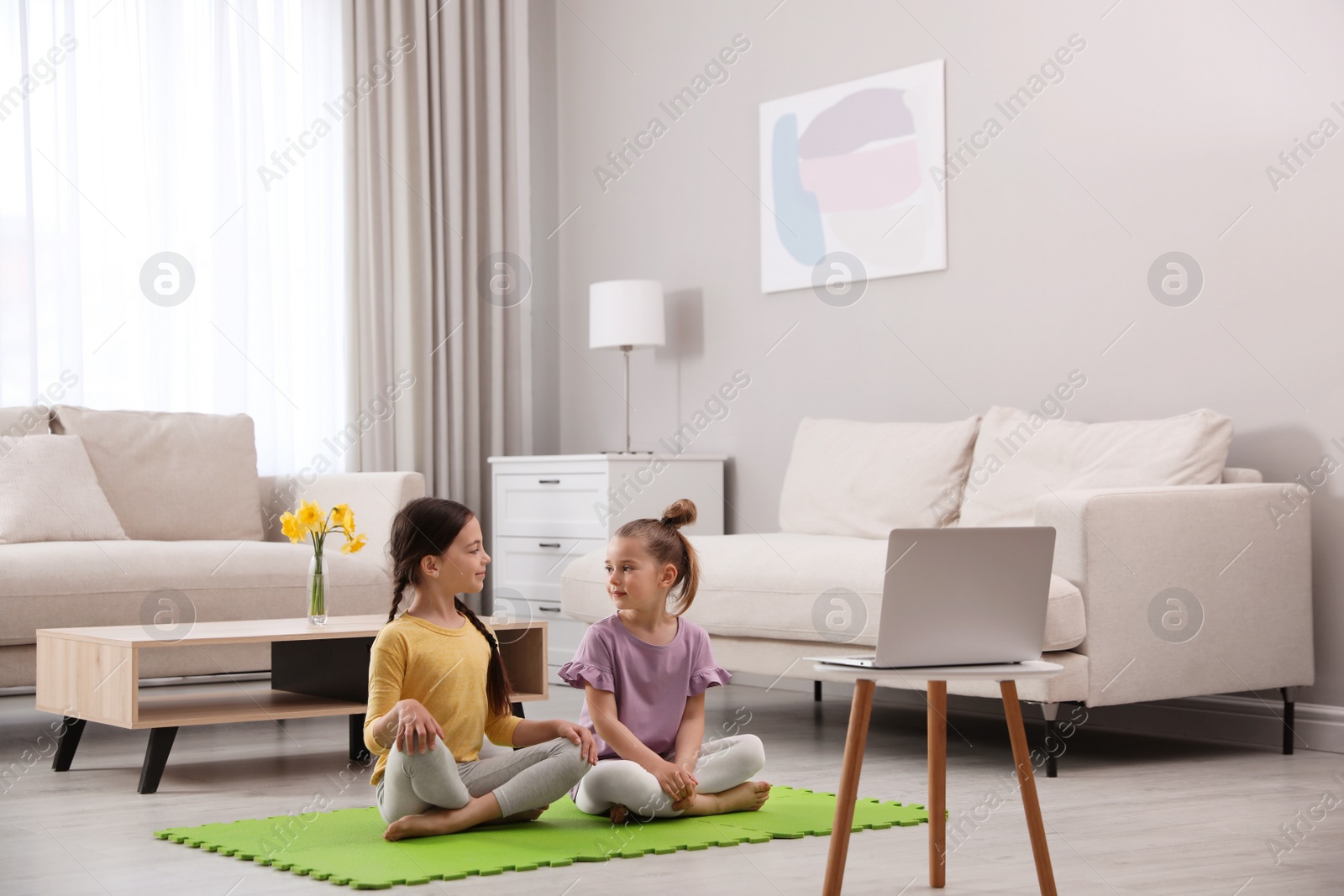 Photo of Cute little girls watching online dance class at home