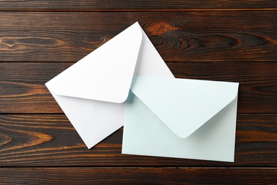 Photo of White paper envelopes on wooden background, flat lay