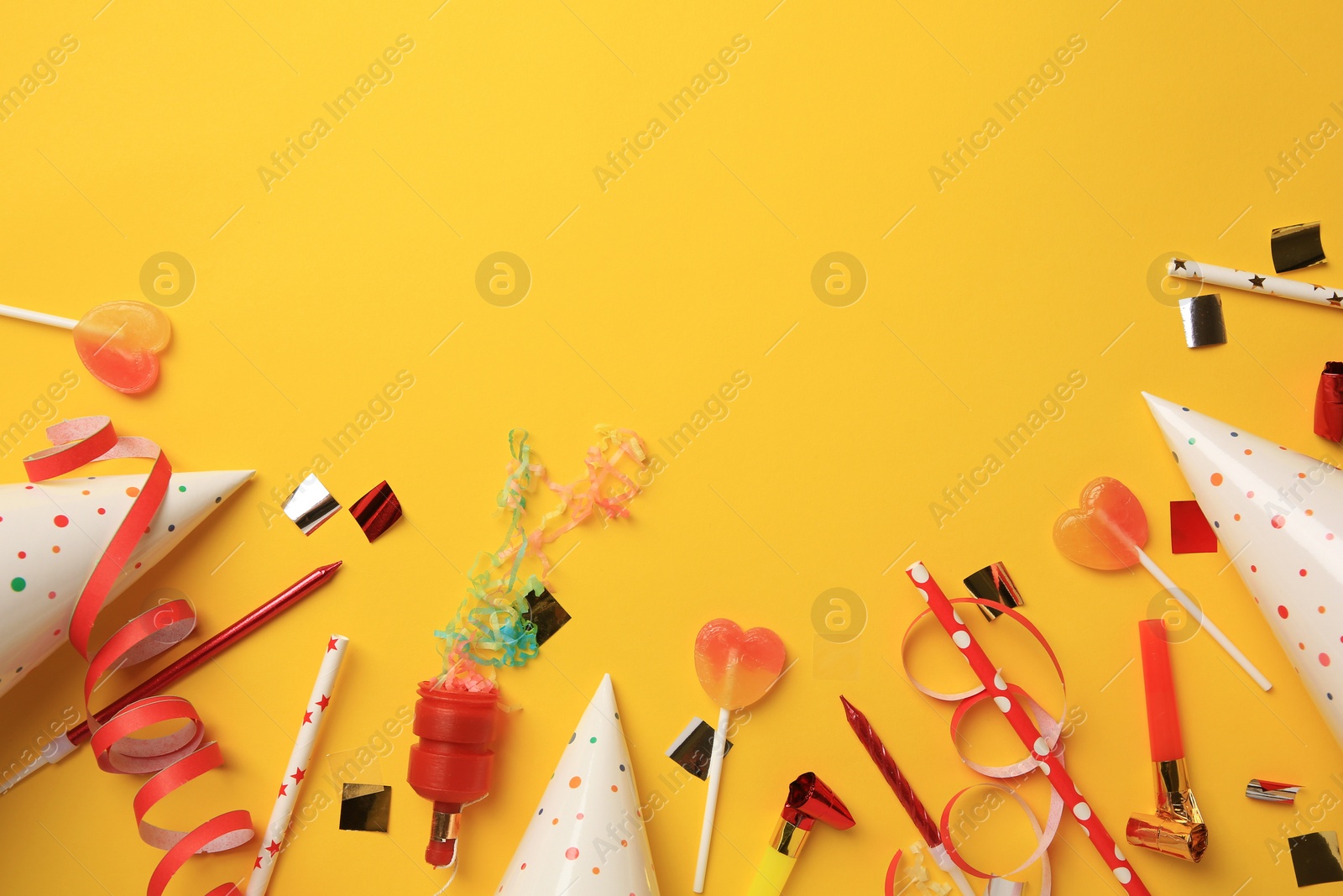 Photo of Party popper, blowers and festive decor on orange background, flat lay. Space for text