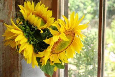 Beautiful sunflowers in vase near window indoors, closeup
