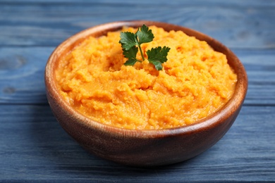 Bowl with mashed sweet potatoes on wooden background