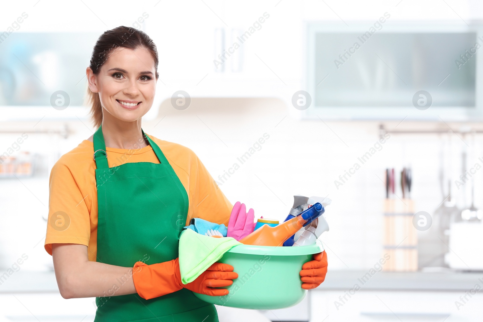 Photo of Woman in uniform with cleaning supplies indoors