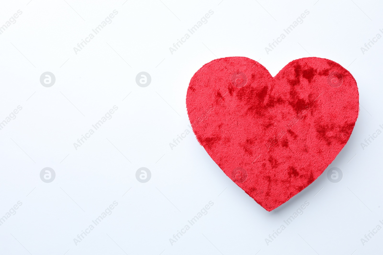 Photo of One velvet heart on white background, top view. Space for text