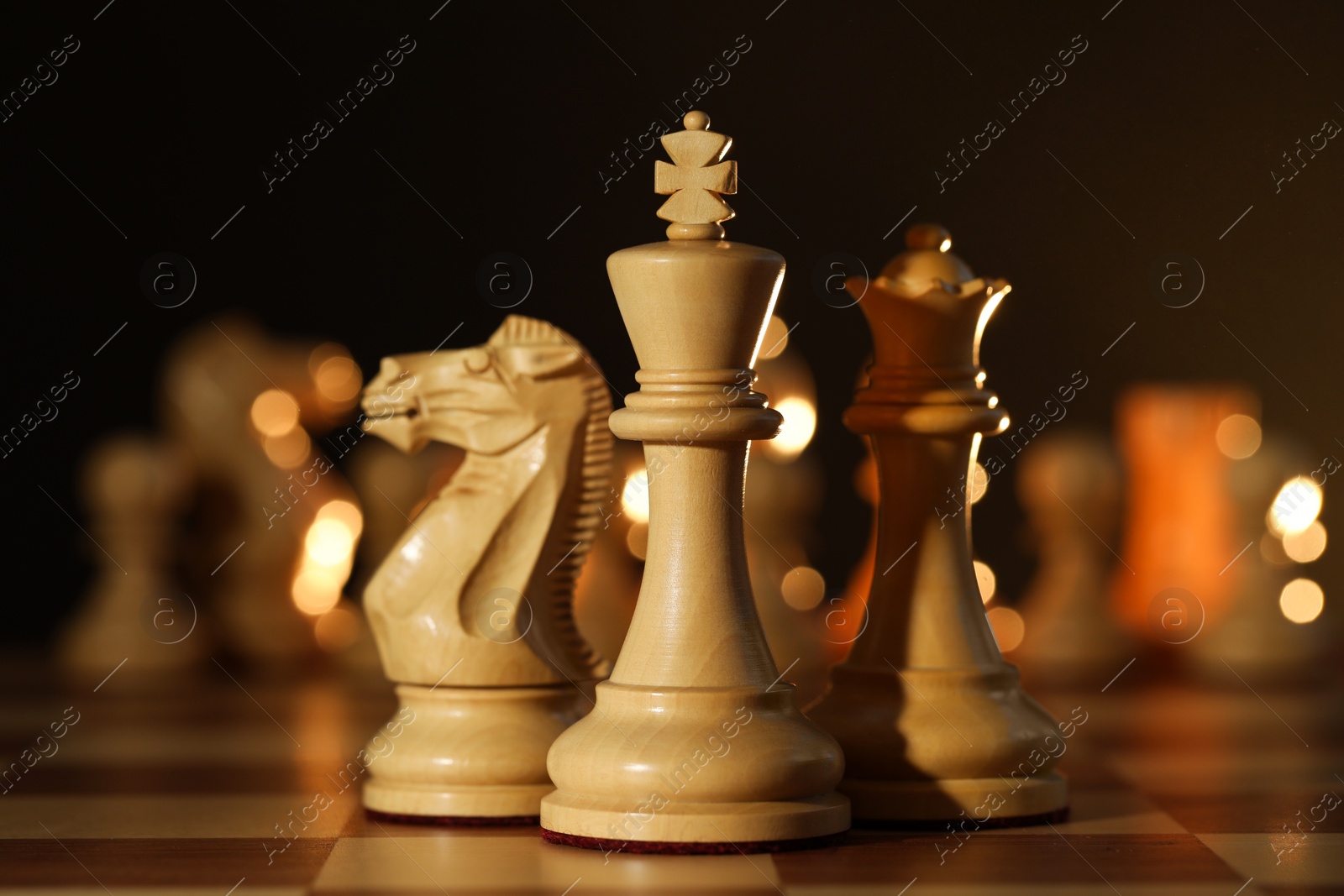 Photo of Wooden king, queen and knight on chessboard, closeup