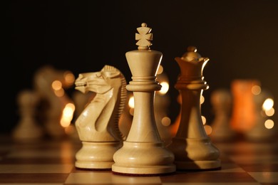 Wooden king, queen and knight on chessboard, closeup