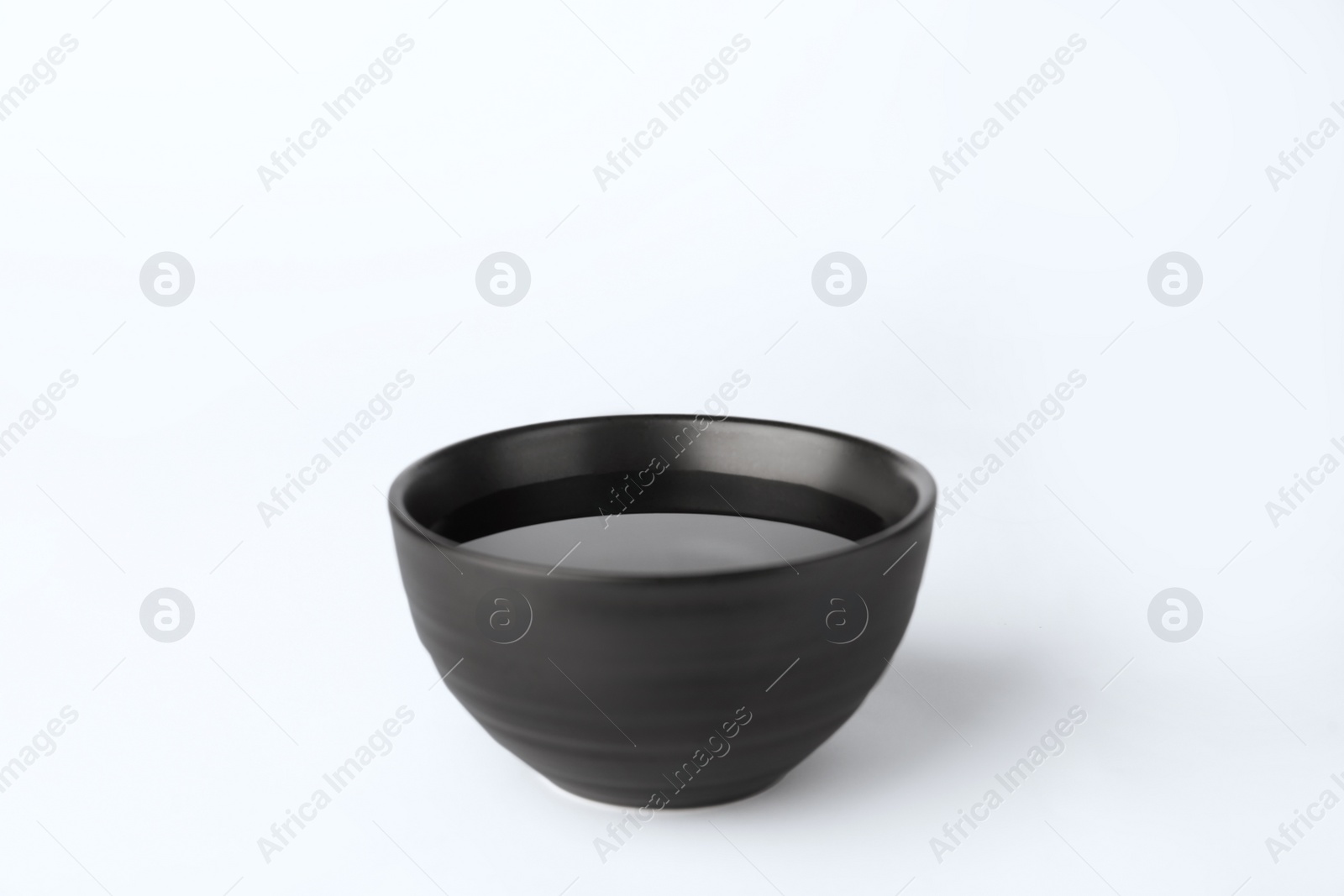 Photo of Black bowl full of water on white background