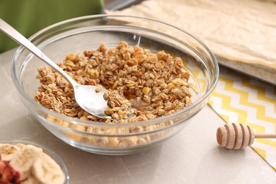 Photo of Making granola. Bowl with mixture of oat flakes and other ingredients on light grey marble table