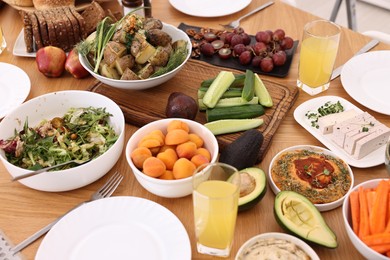 Healthy vegetarian food and glasses of juice on wooden table