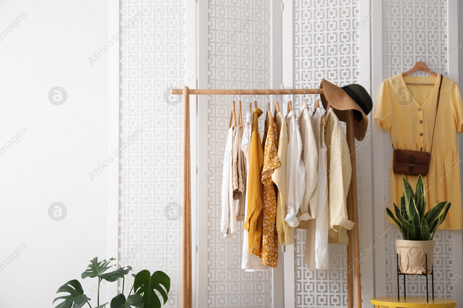 Photo of Rack with stylish women's clothes indoors. Interior design