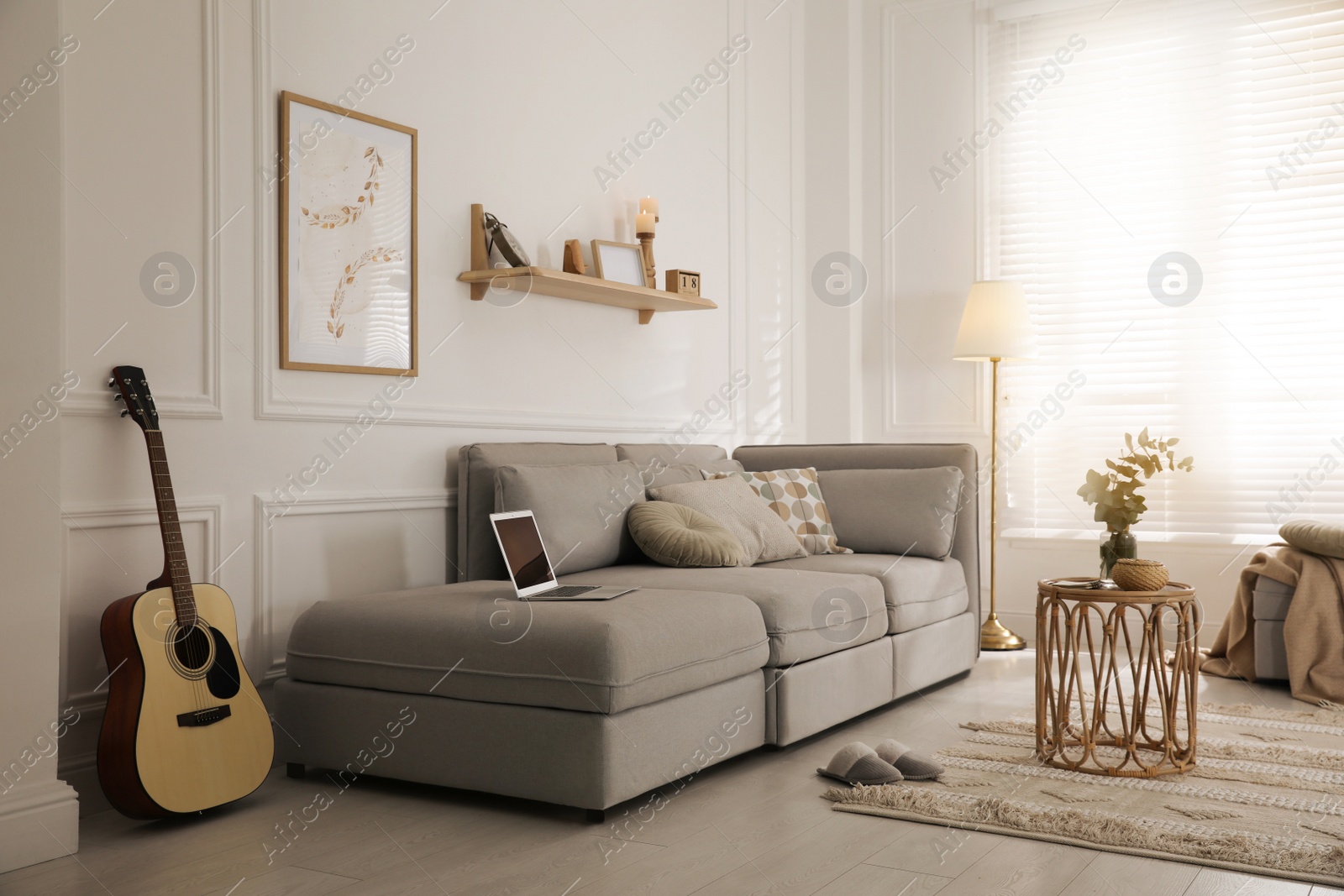 Photo of Living room with comfortable grey sofa and stylish interior elements near window