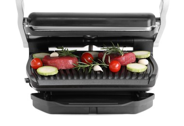 Photo of Electric grill with raw meat, rosemary and vegetables isolated on white