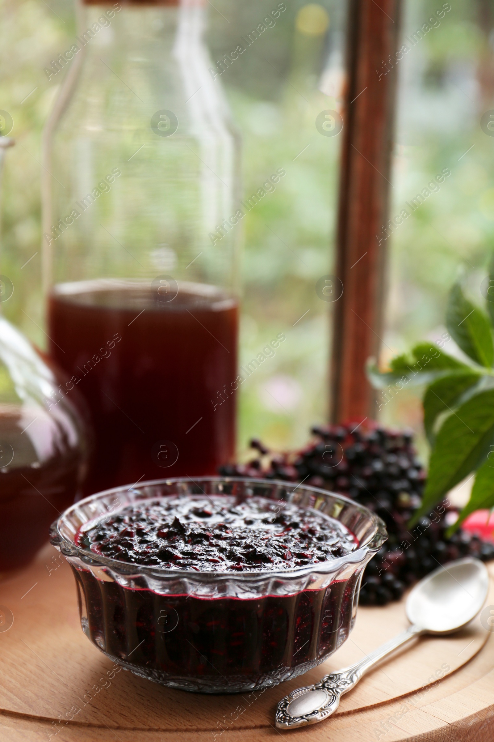 Photo of Elderberry jam and drink with Sambucus berries on table near window
