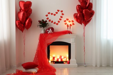 Photo of Stylish room with fireplace and Valentine's day decor. Interior design
