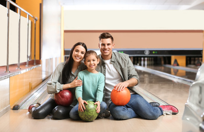 Happy family spending time together in bowling club