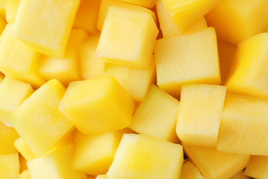 Many delicious mango cubes as background, closeup