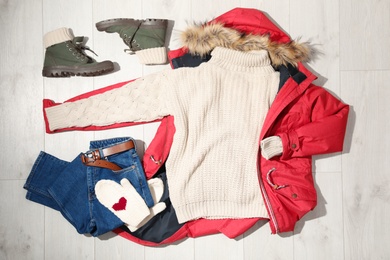 Set of stylish winter outfit on wooden background, flat lay