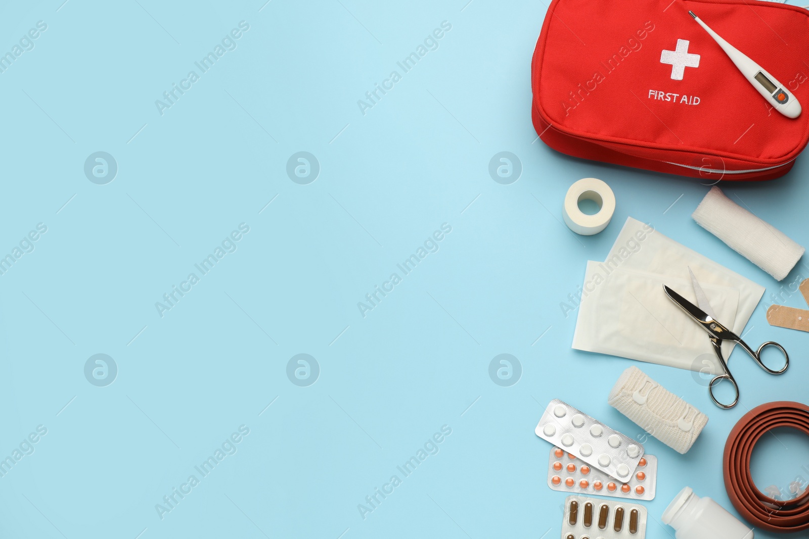 Photo of Flat lay composition with first aid kit on light blue background, space for text