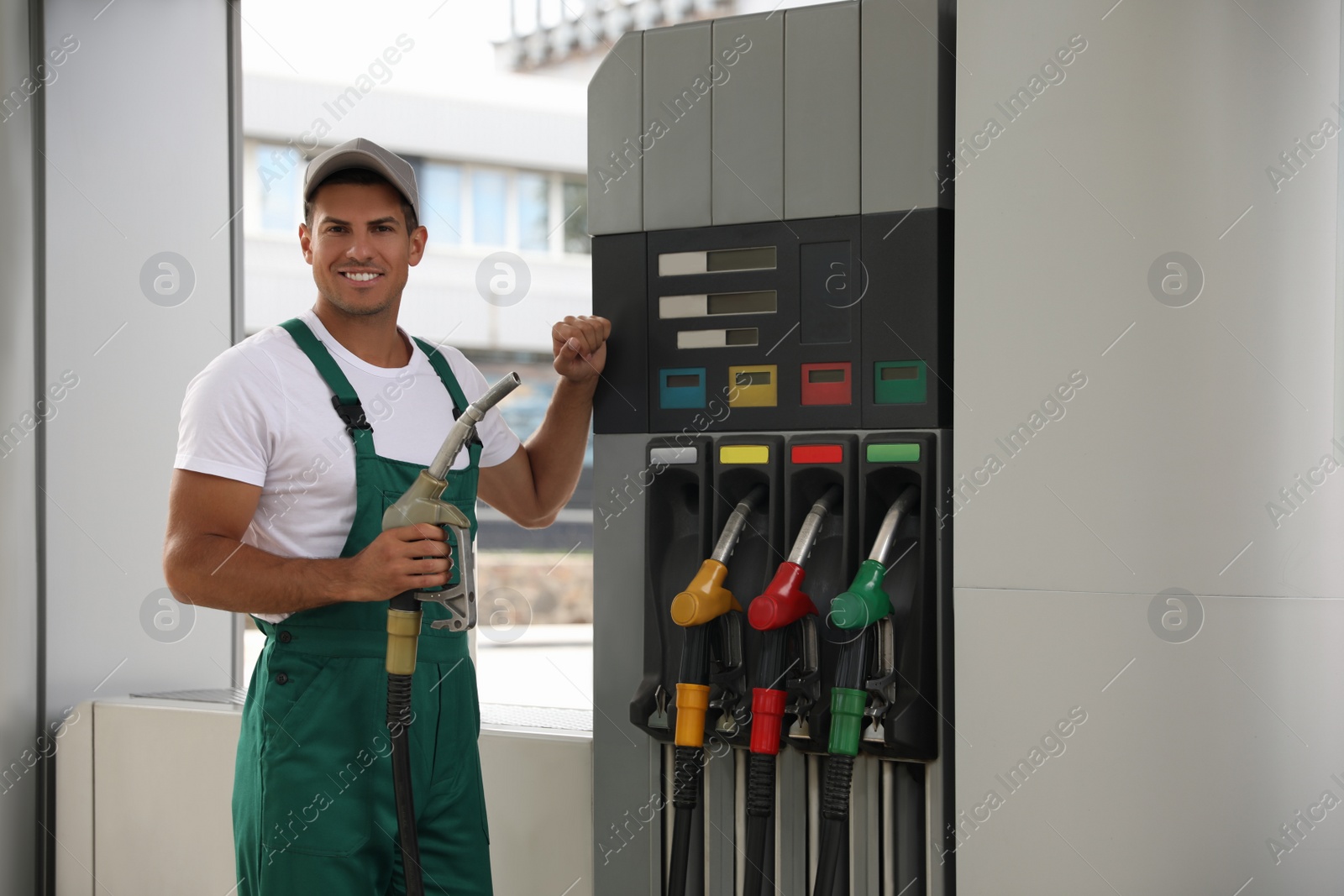 Photo of Worker with fuel pump nozzle at modern gas station