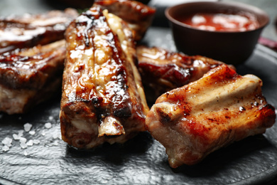 Delicious grilled ribs on board, closeup view