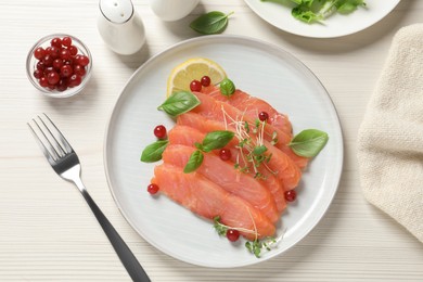 Delicious salmon carpaccio served on white wooden table, flat lay