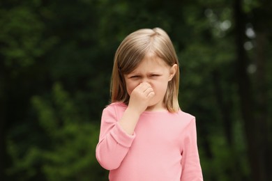 Photo of Little girl suffering from seasonal spring allergy outdoors