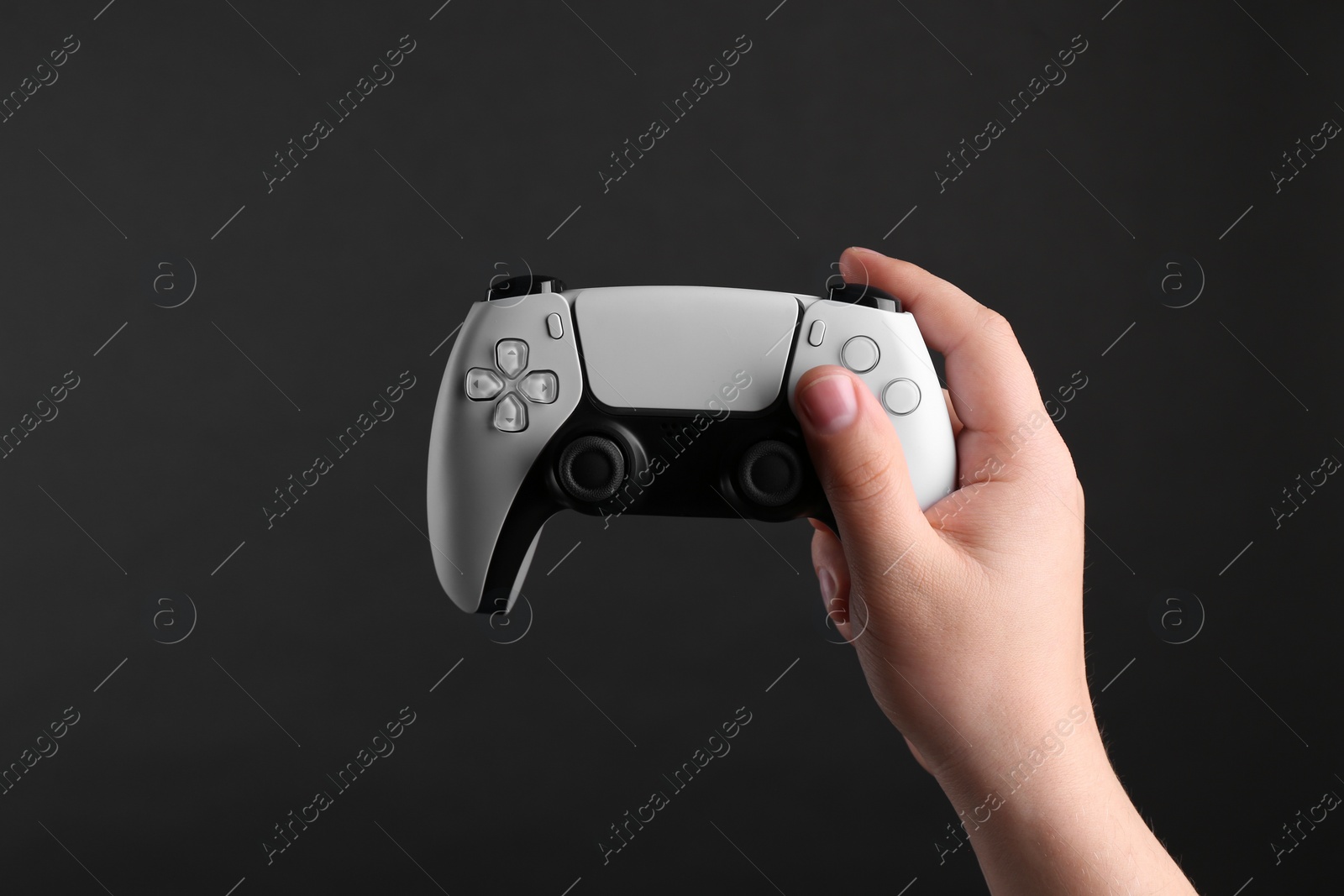 Photo of Woman using wireless game controller on dark background, closeup