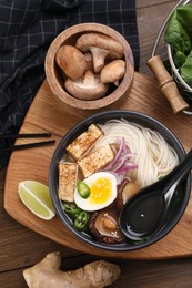 Flat lay composition with delicious vegetarian ramen and products on wooden table