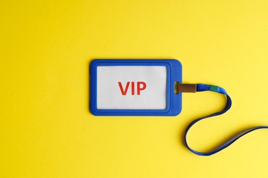 Photo of Vip badge on yellow background, top view. Space for text