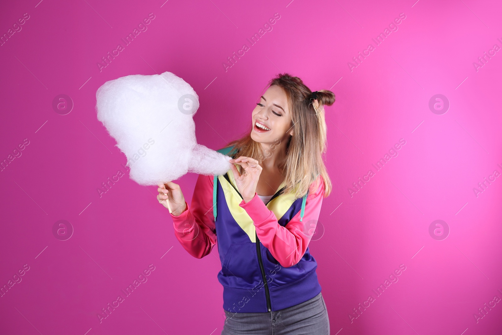 Photo of Young pretty woman with cotton candy on colorful background