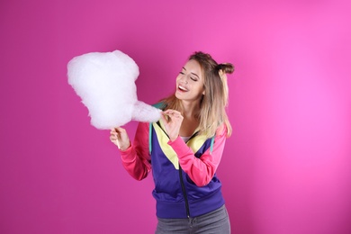 Photo of Young pretty woman with cotton candy on colorful background